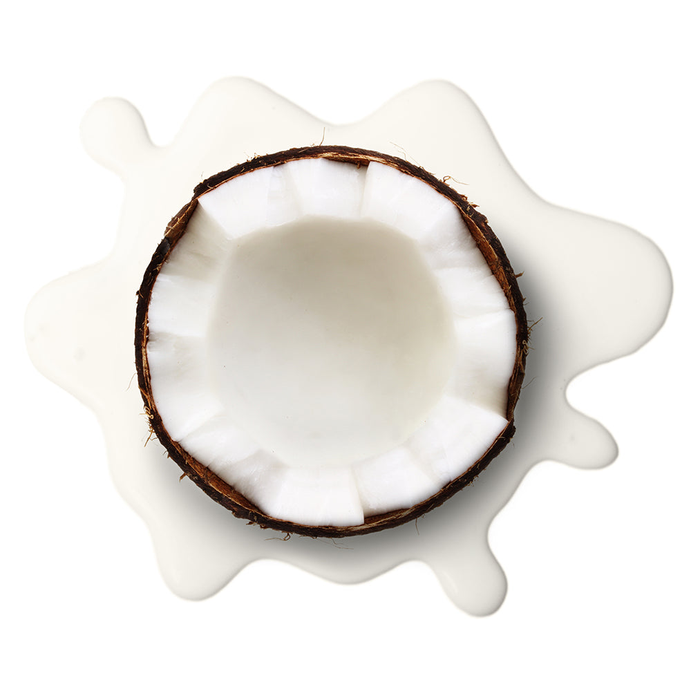 close up of half of a coconut sitting on top of coconut milk
