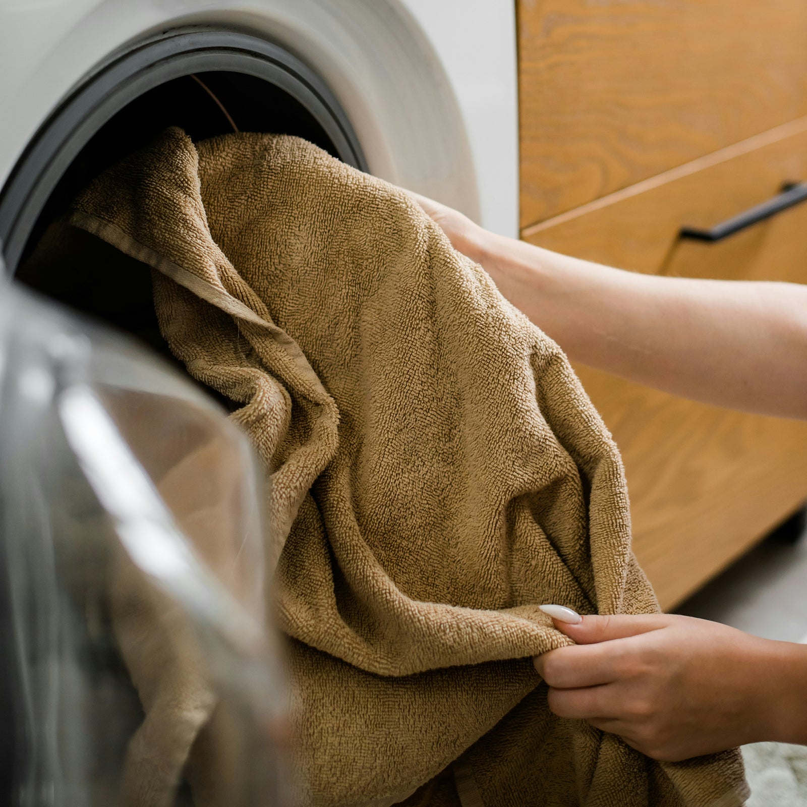 a person putting towels in a dryer